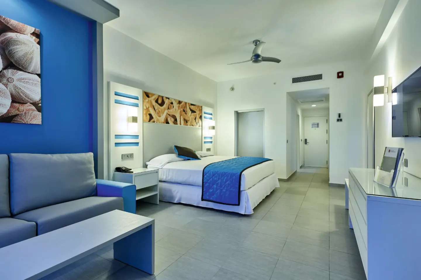 Partial Ocean View room with king bed and sofa at Hotel Riu Dunamar.