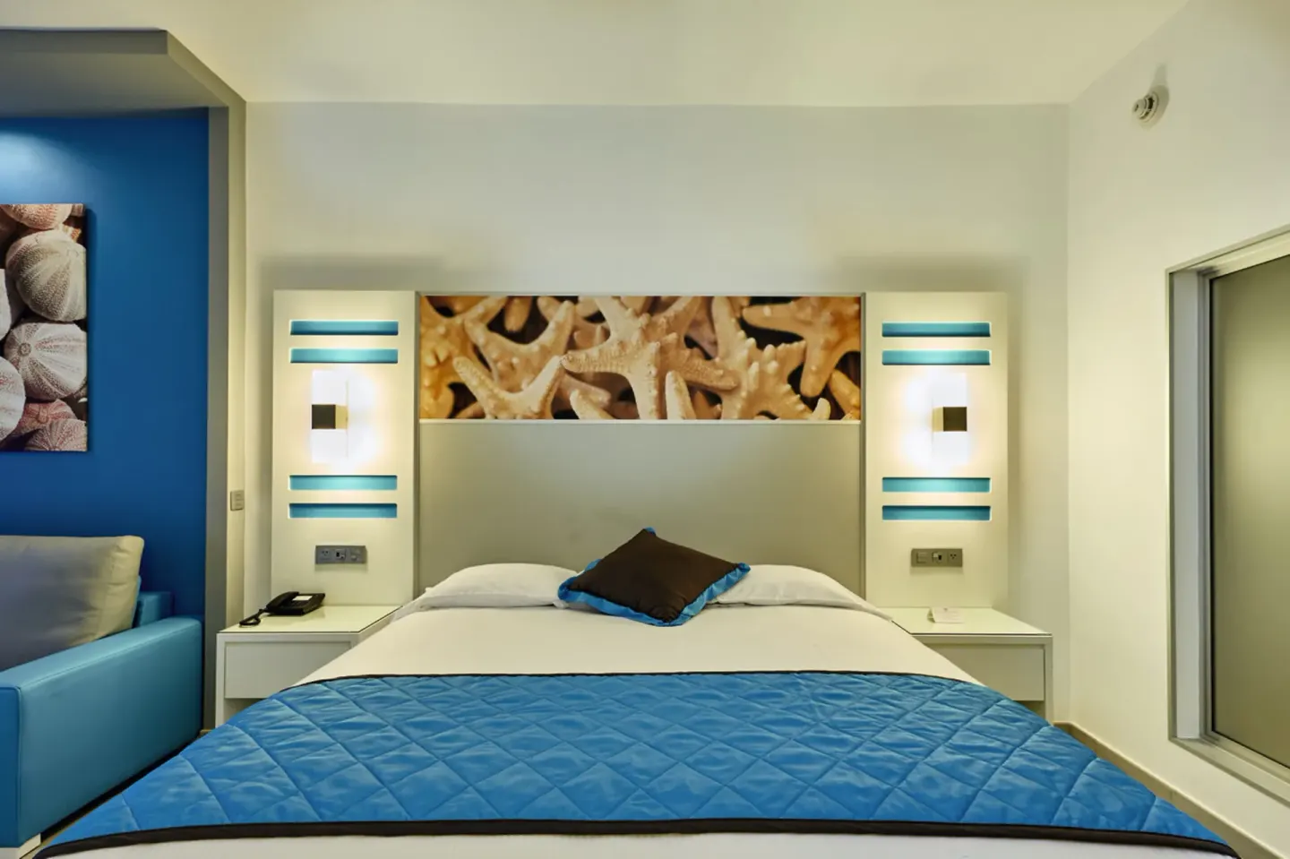 Partial Ocean View room king bed with starfish artwork at Hotel Riu Dunamar.
