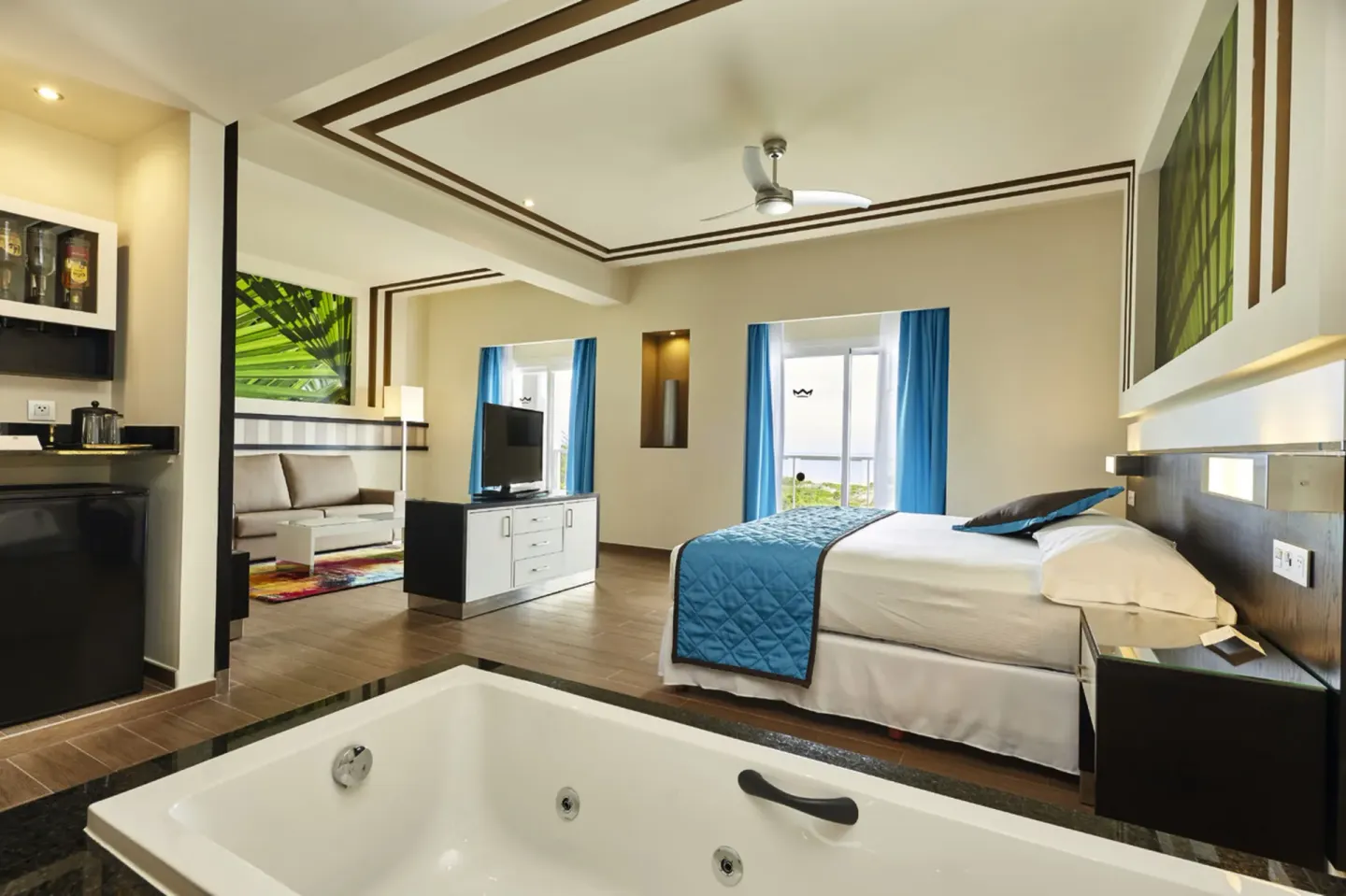 Suite with king bed, in-room tub, and lounge area at Hotel Riu Dunamar.