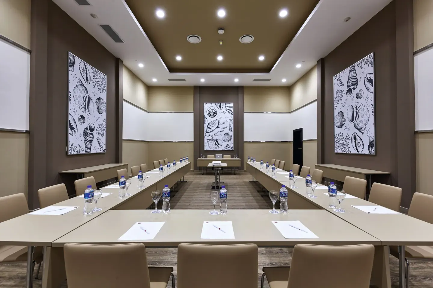 Meeting room with U-shaped tables and shell artwork at Hotel Riu Dunamar.