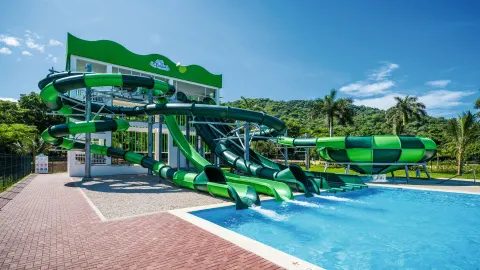 Green waterslides emptying into a pool at Hotel Riu Guanacaste.