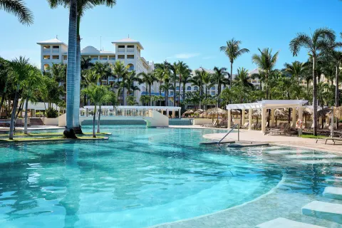 Main pool with palms, loungers and resort buildings at Hotel Riu Guanacaste.