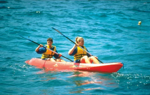 Two guests kayaking on blue ocean water at Hotel Riu Guanacaste.