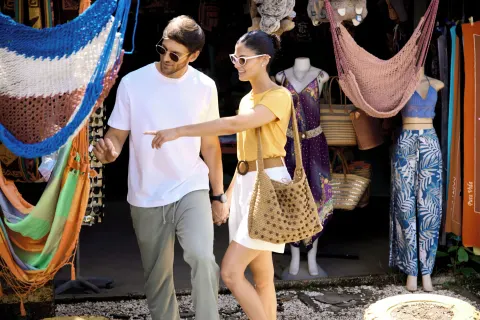 Couple browsing hammocks and resort wear near Hotel Riu Guanacaste.