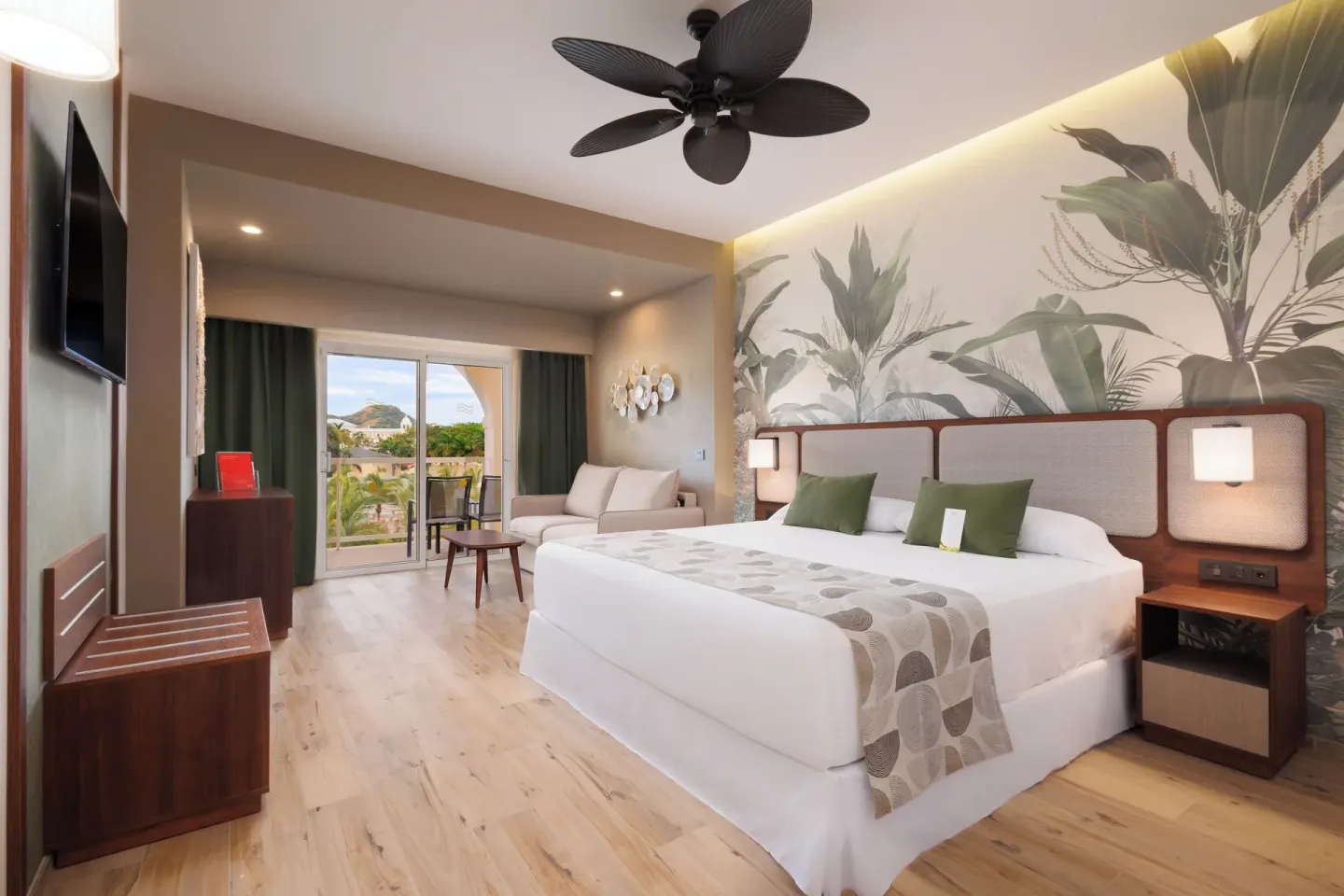 Deluxe Room Pool View with balcony doors and king bed at Hotel Riu Guanacaste.