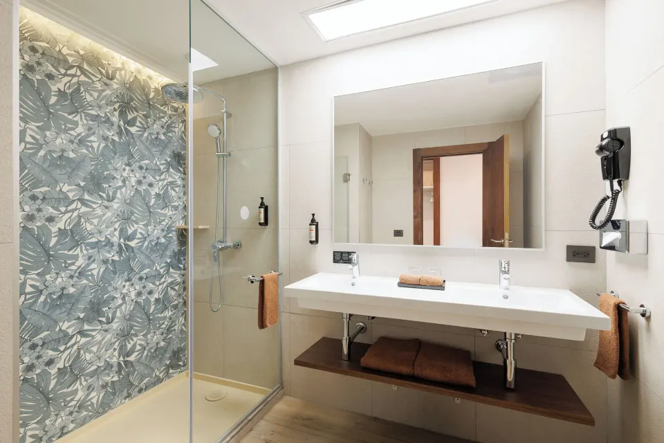 Deluxe Room bathroom with double sink and glass shower at Hotel Riu Guanacaste.