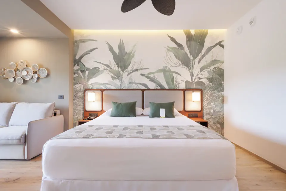 Deluxe Room king bed with botanical wall mural at Hotel Riu Guanacaste.