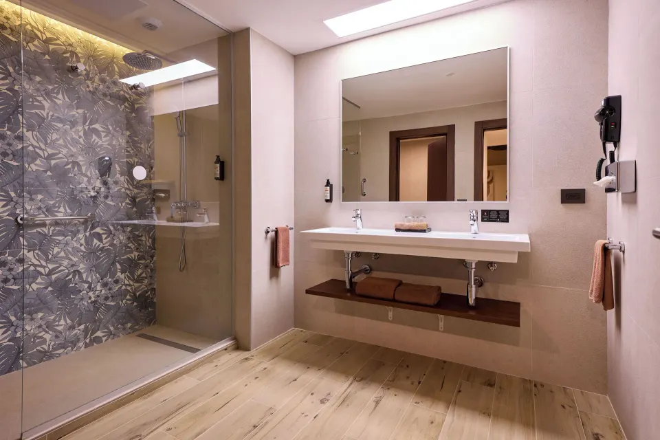 Family Room bathroom with double sink and glass shower at Hotel Riu Guanacaste.