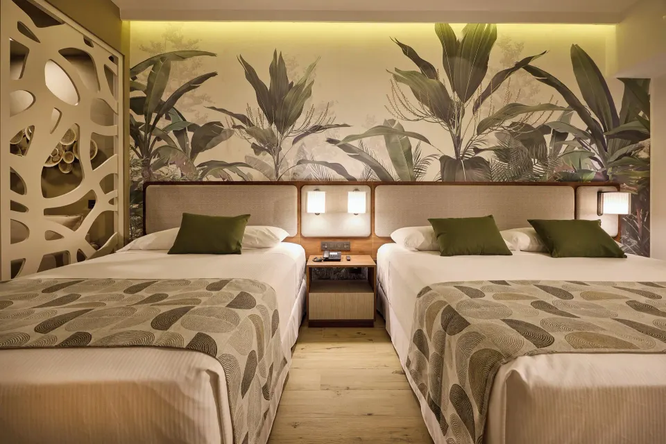 Family Room beds with bedside lighting and leaf mural at Hotel Riu Guanacaste.