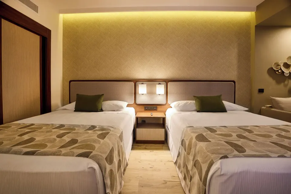 Family Suite second bedroom with two beds and central nightstand at Hotel Riu Guanacaste.