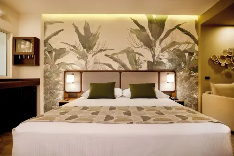Swim-up adults-only room bed with tropical mural at Hotel Riu Guanacaste.