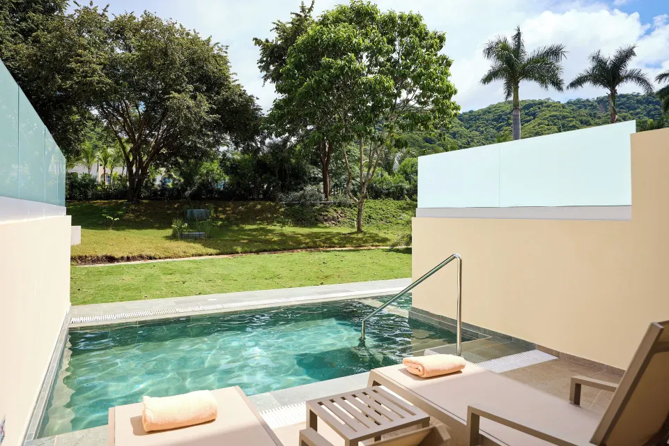 Private swim-up terrace with loungers and garden view at Hotel Riu Guanacaste.