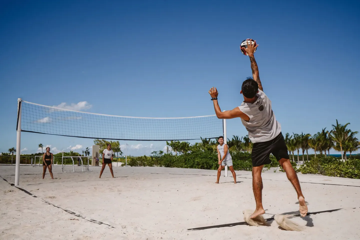 Guests play beach volleyball on the sand at Hotel Riu Latino.