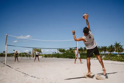 Guests play beach volleyball on the sand at Hotel Riu Latino.
