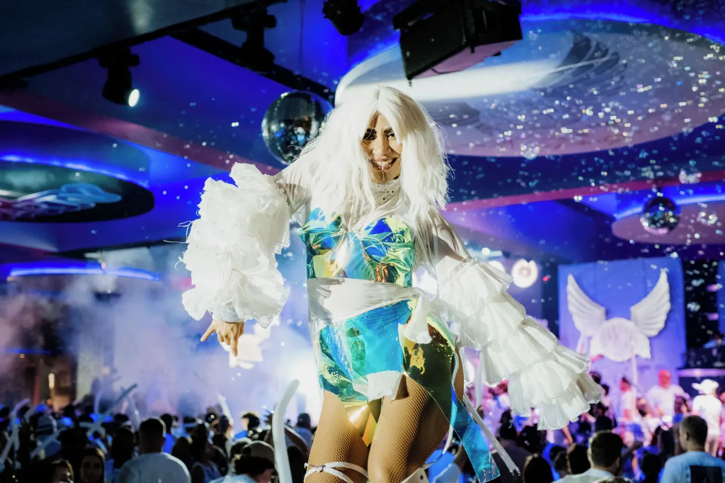 A costumed performer stands above a crowd during a party at Hotel Riu Latino.