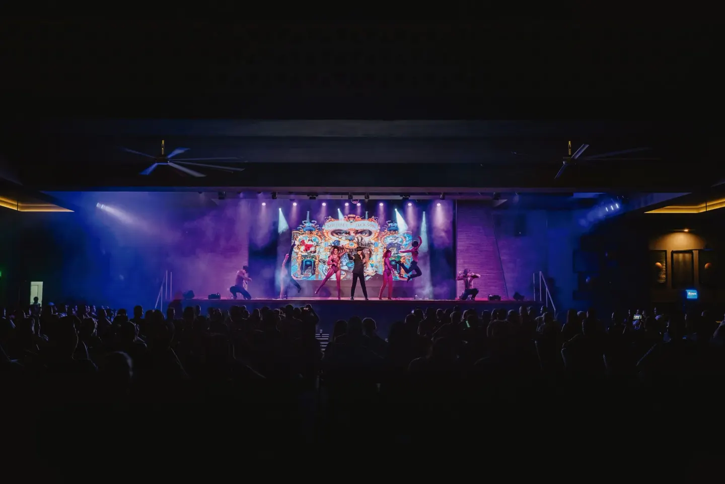 A nighttime stage show plays to a seated audience at Hotel Riu Latino.