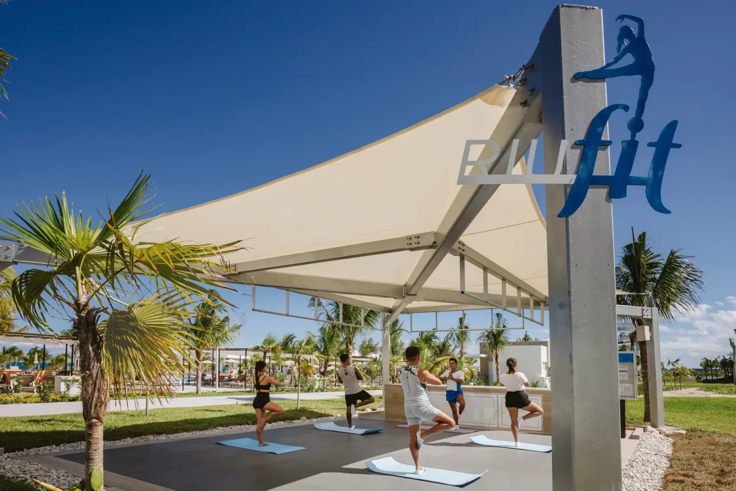 RIU Fit pavilion with guests balancing on mats at Hotel Riu Latino.