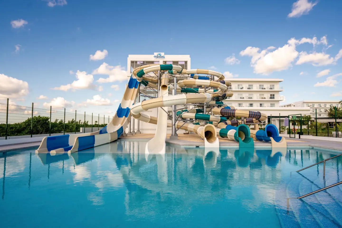 Water slide complex and pool at Hotel Riu Latino under a blue sky.