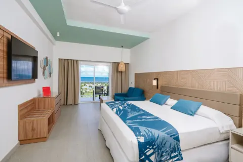 Ocean View Standard Room with king bed, sofa, and balcony at Hotel Riu Latino.