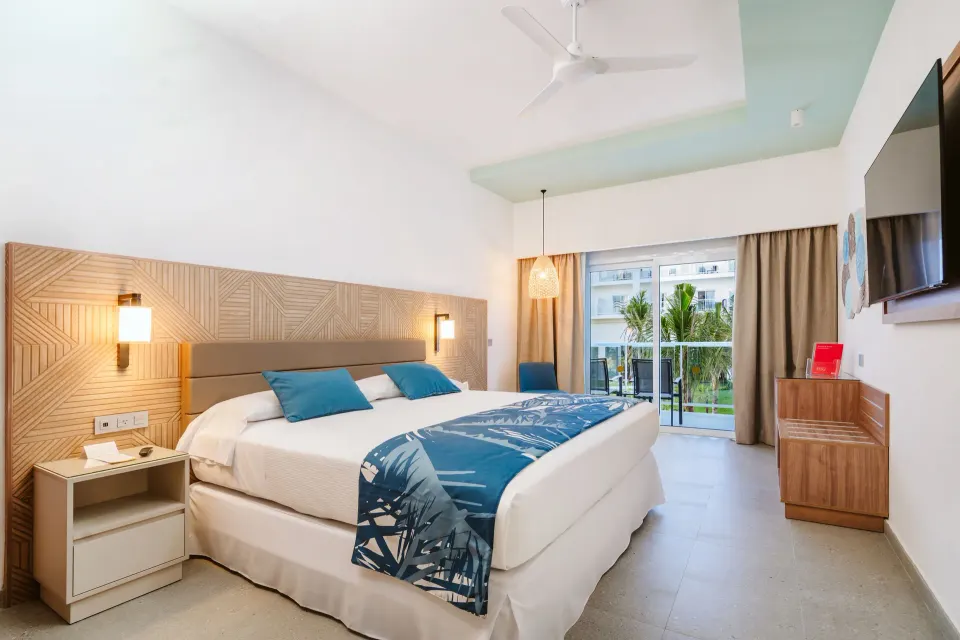 Standard Room with tropical-view balcony and king bed at Hotel Riu Latino.