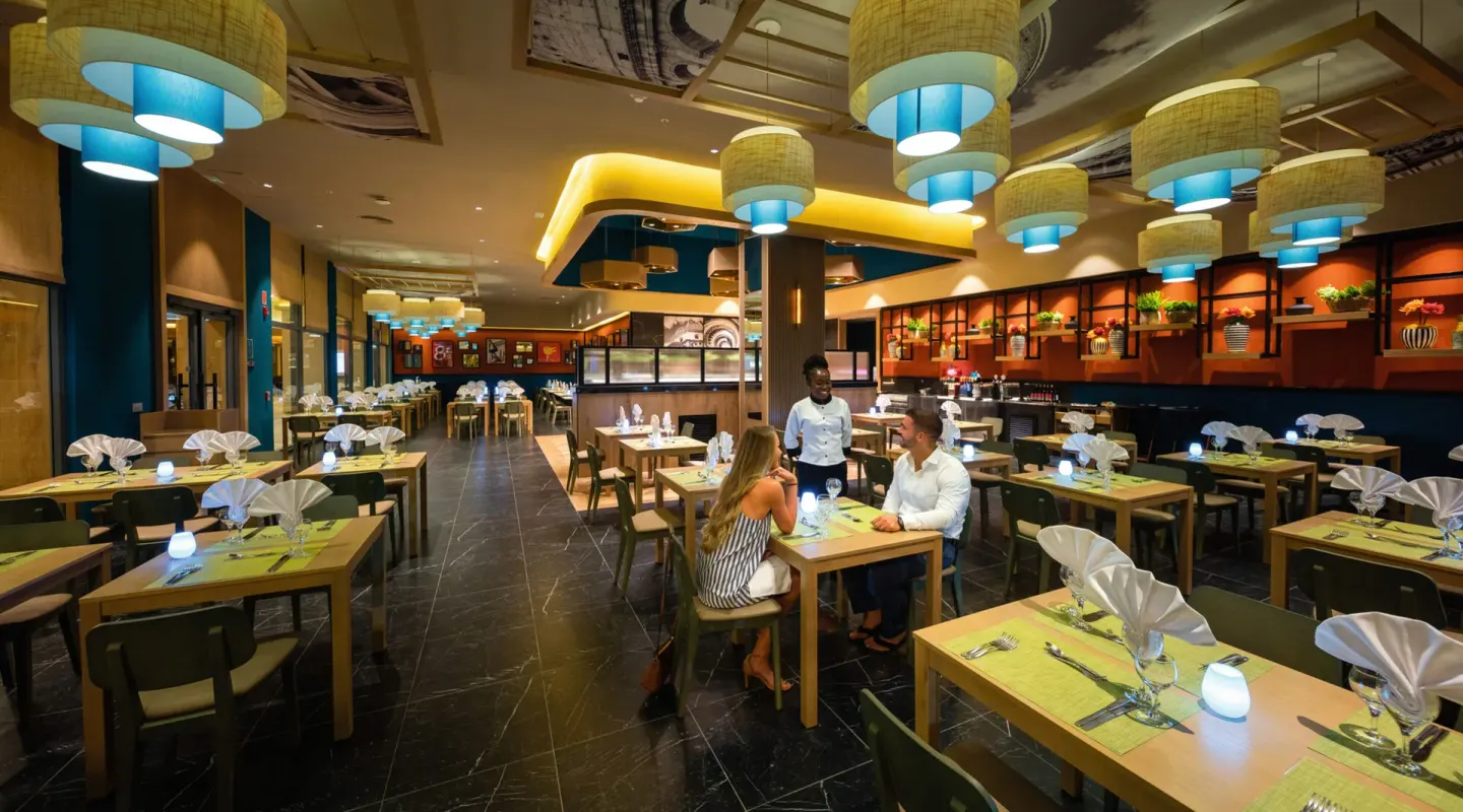 Italian-themed dining room with pendant lights and set tables at Hotel Riu Montego Bay.