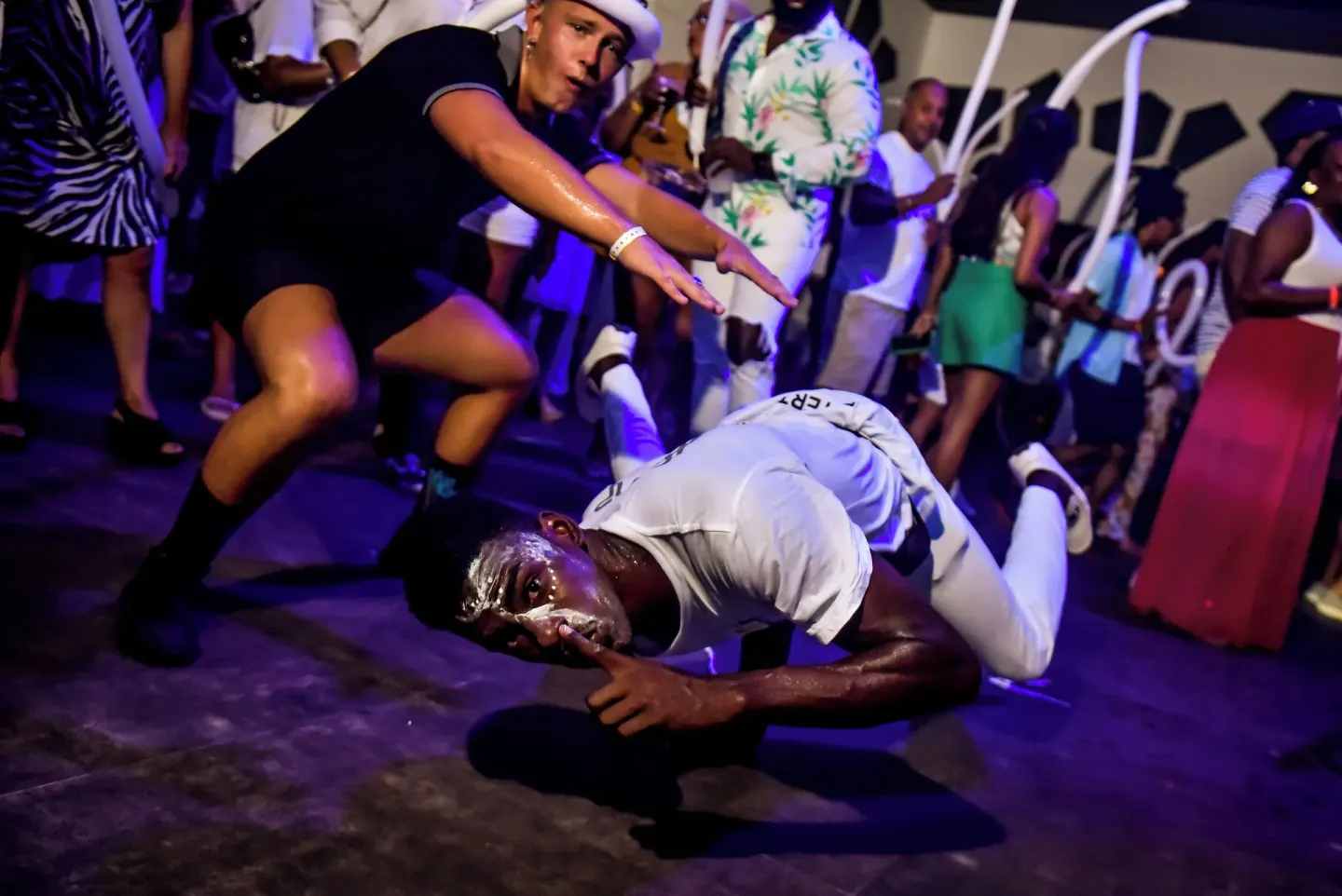 A dancer performs low to the floor during a nighttime party at Hotel Riu Ocho Rios.
