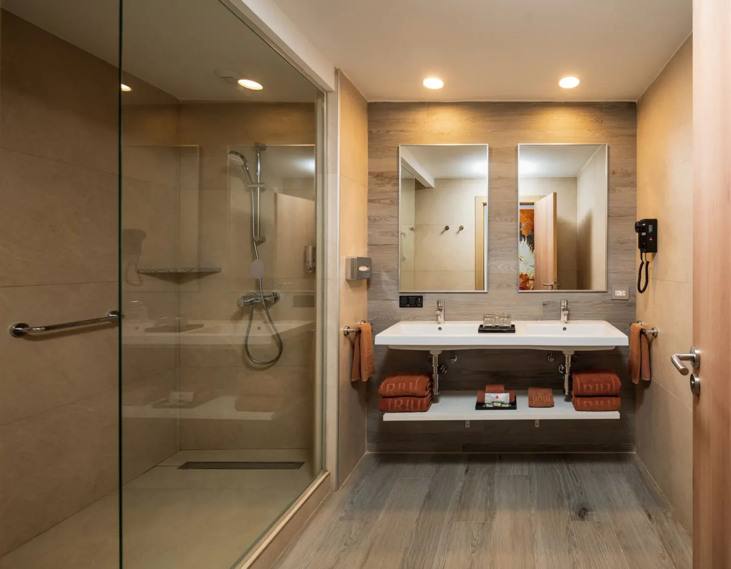 Family Room bathroom with glass shower and double vanity at Hotel Riu Ocho Rios.