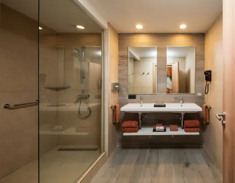 Family Room bathroom with glass shower and double vanity at Hotel Riu Ocho Rios.