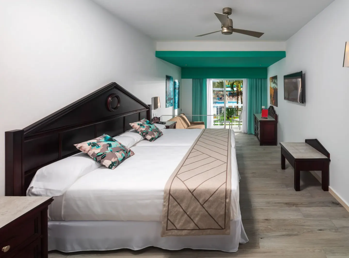 Junior Suite Garden View with two beds and balcony doors at Hotel Riu Ocho Rios.