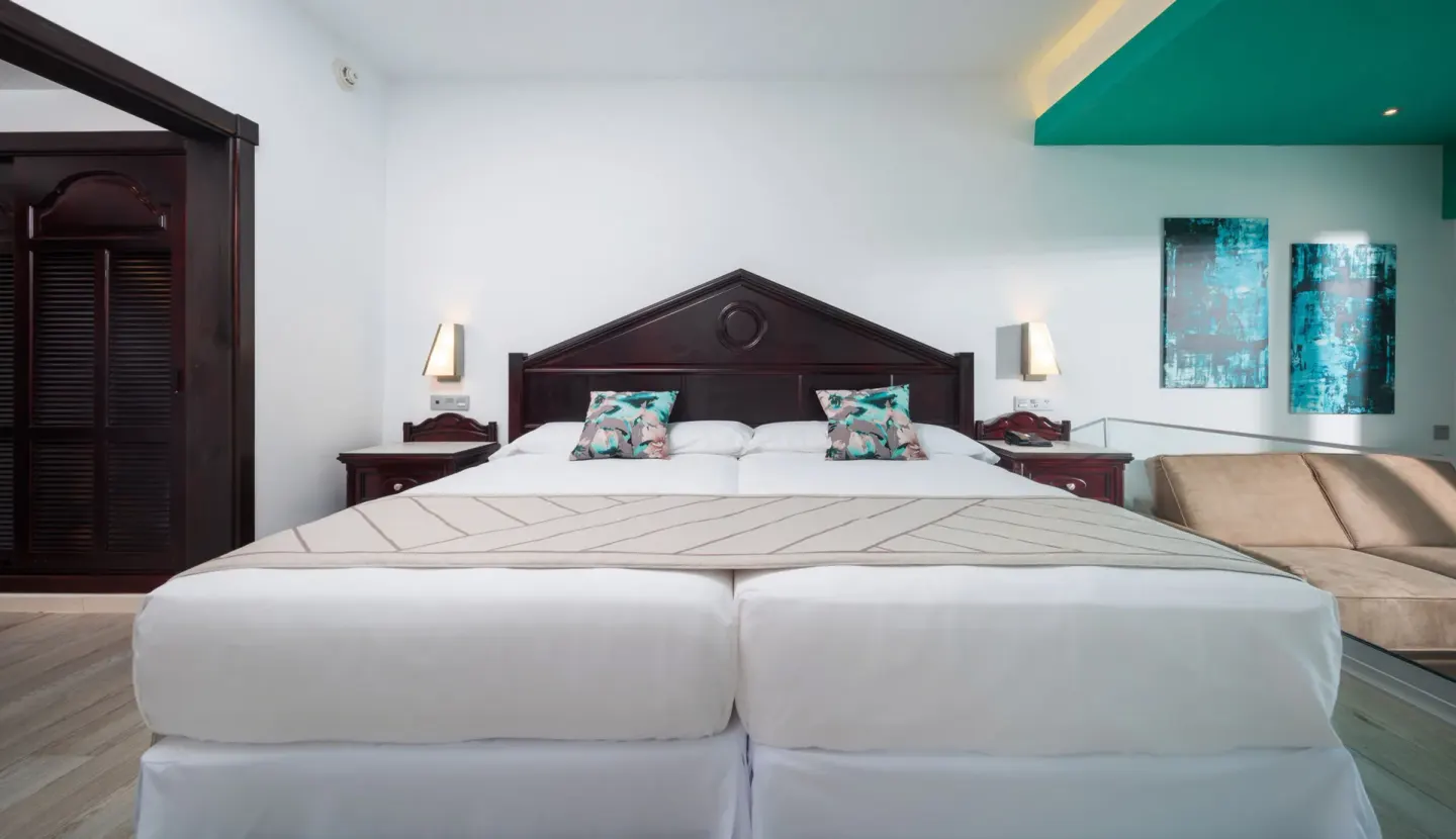 Junior Suite Garden View bed and sofa area at Hotel Riu Ocho Rios.