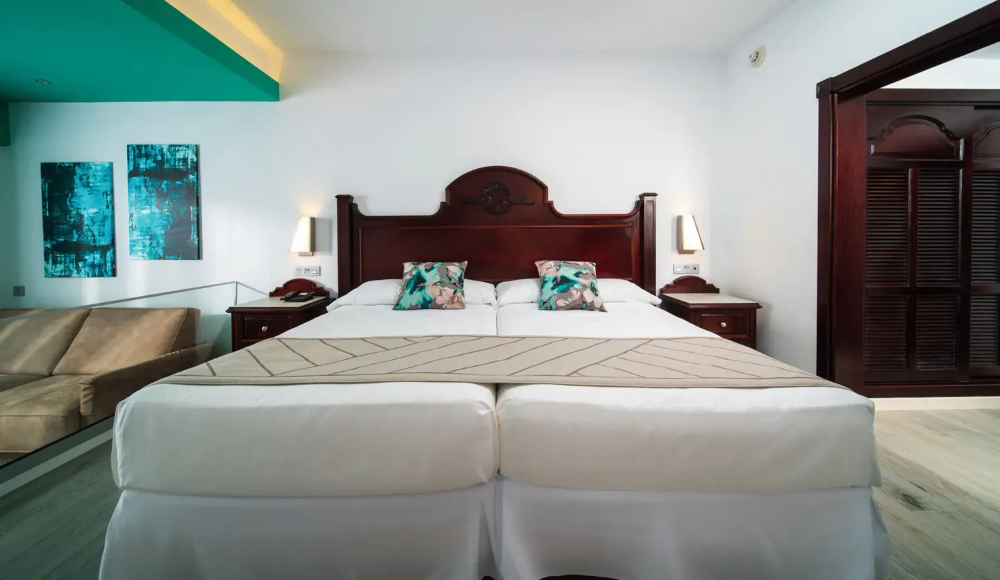 Junior Suite Ocean View bed with sofa and wardrobe at Hotel Riu Ocho Rios.