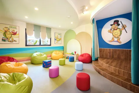 A colorful children's playroom with beanbags is shown at Hotel Riu Palace Aquarelle.