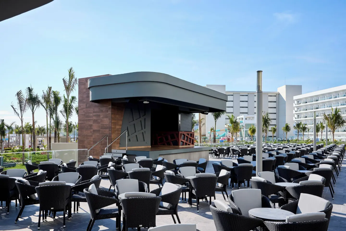An outdoor stage and rows of terrace seating are shown at Hotel Riu Palace Aquarelle.