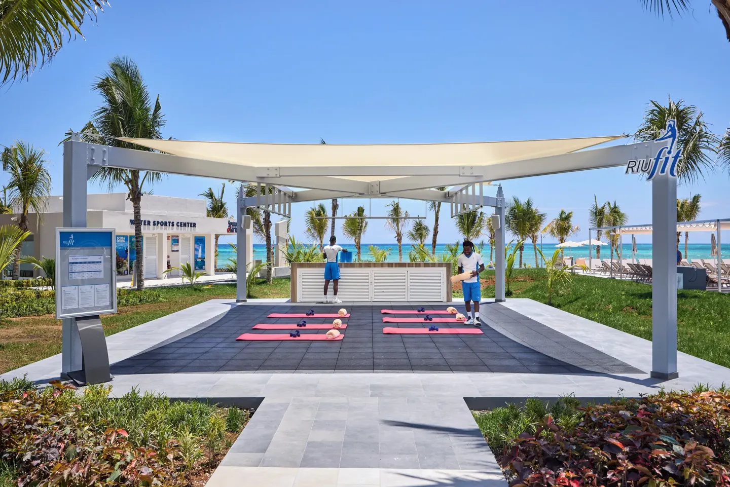 Outdoor fitness pavilion with exercise mats by the beach at Hotel Riu Palace Aquarelle.
