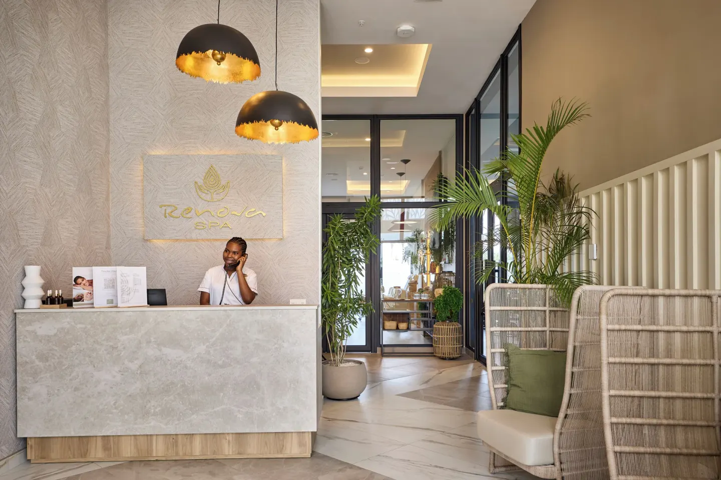 Renova Spa reception desk with plants and seating at Hotel Riu Palace Aquarelle.