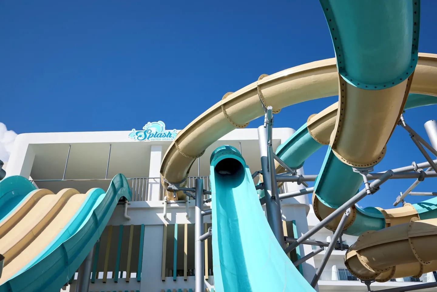 Close-up of twisting aqua and beige water slides at Hotel Riu Palace Aquarelle.