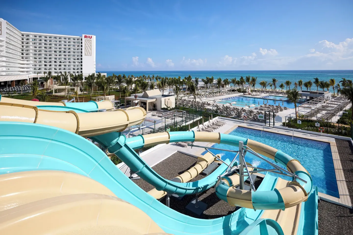 Water slides, pools and beachfront hotel tower at Hotel Riu Palace Aquarelle.