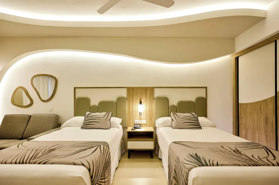 Junior Suite Partial Ocean View with two beds and sofa at Hotel Riu Palace Aquarelle.