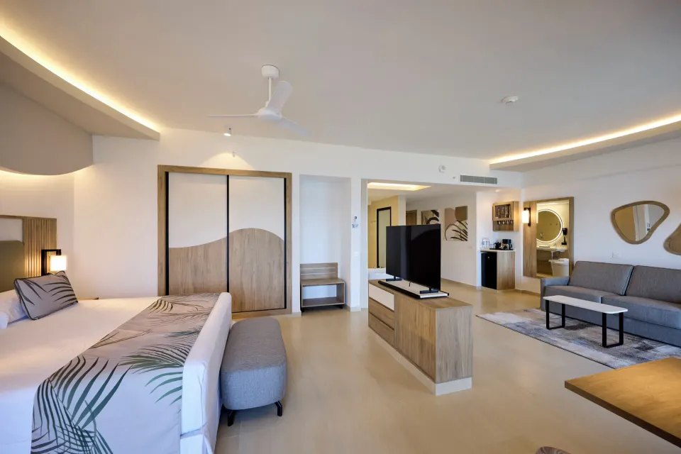 Ocean View Suite bed, sofa lounge and TV console at Hotel Riu Palace Aquarelle.