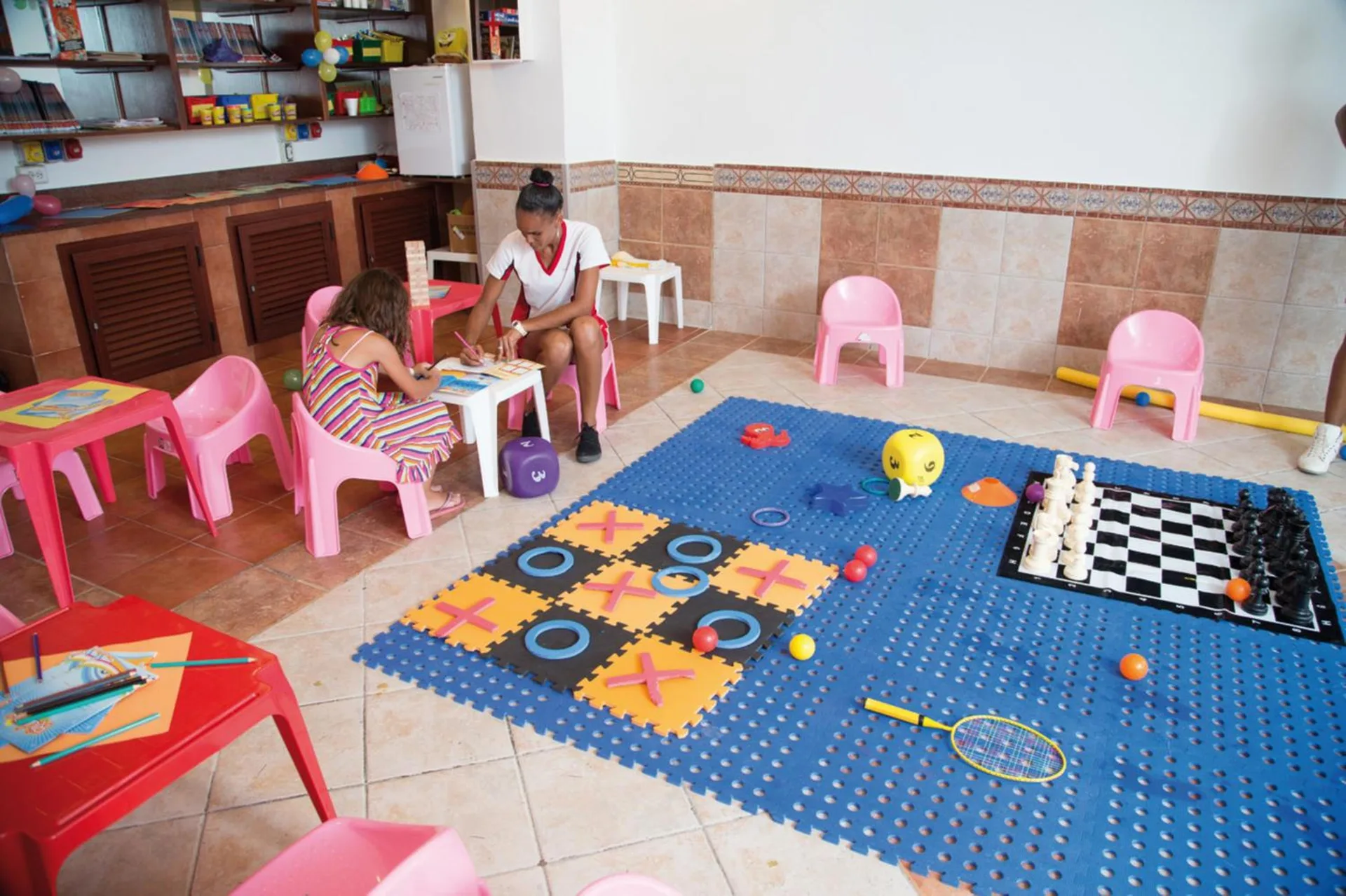 A children's playroom with games and small tables at Hotel Riu Palace Aruba.