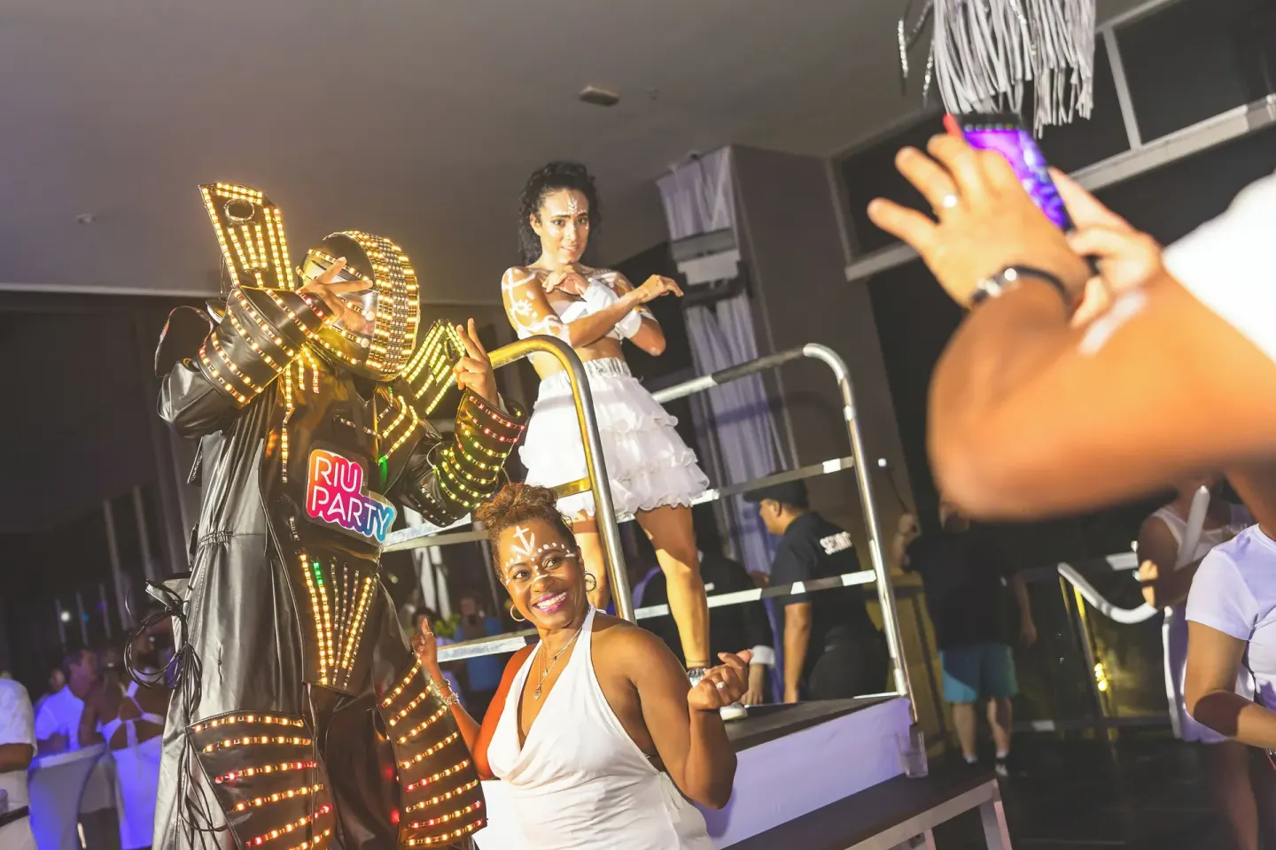 Costumed performers pose with guests during a party at Hotel Riu Palace Aruba.