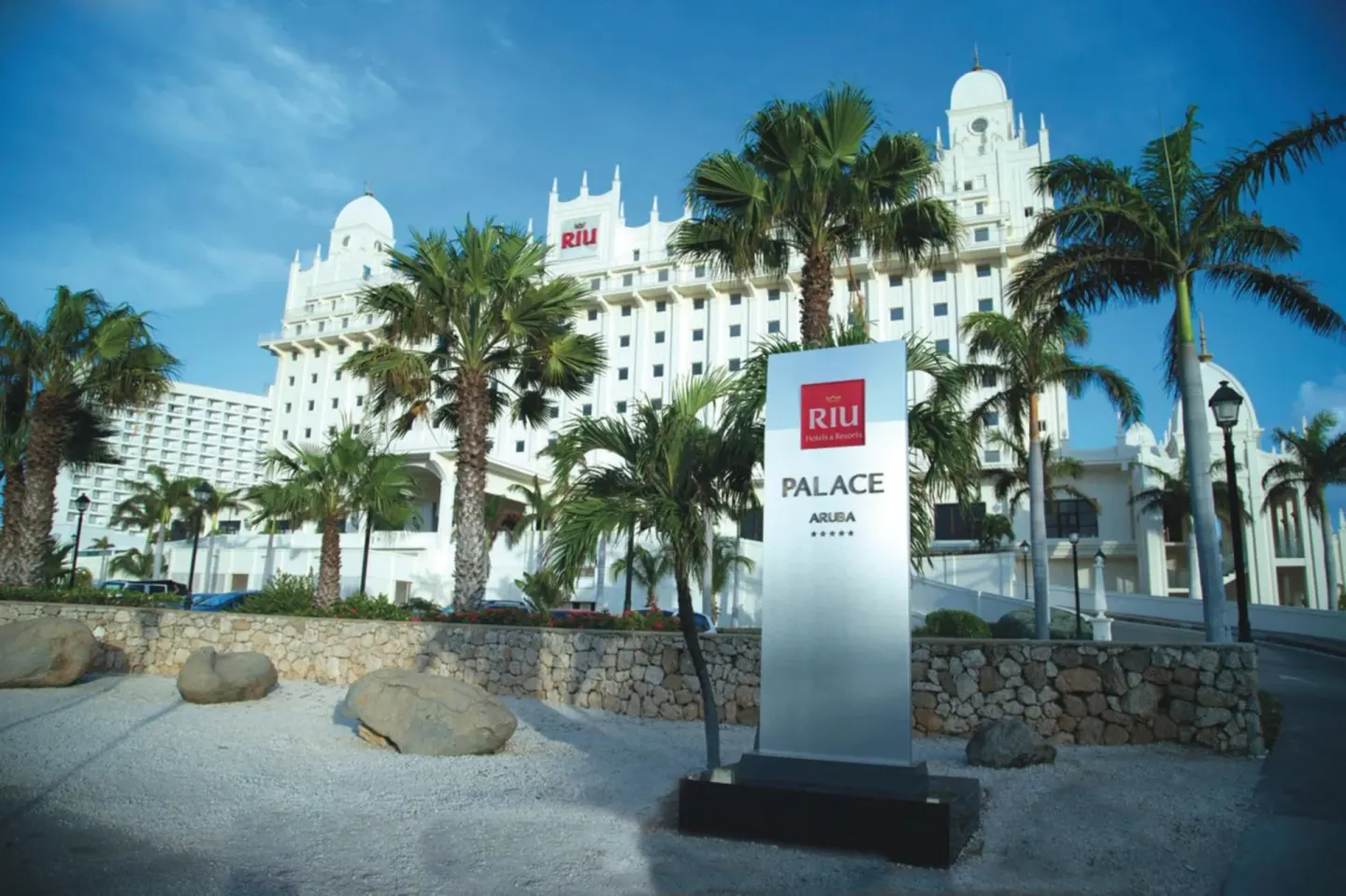 Entrance sign and white resort tower at Hotel Riu Palace Aruba.