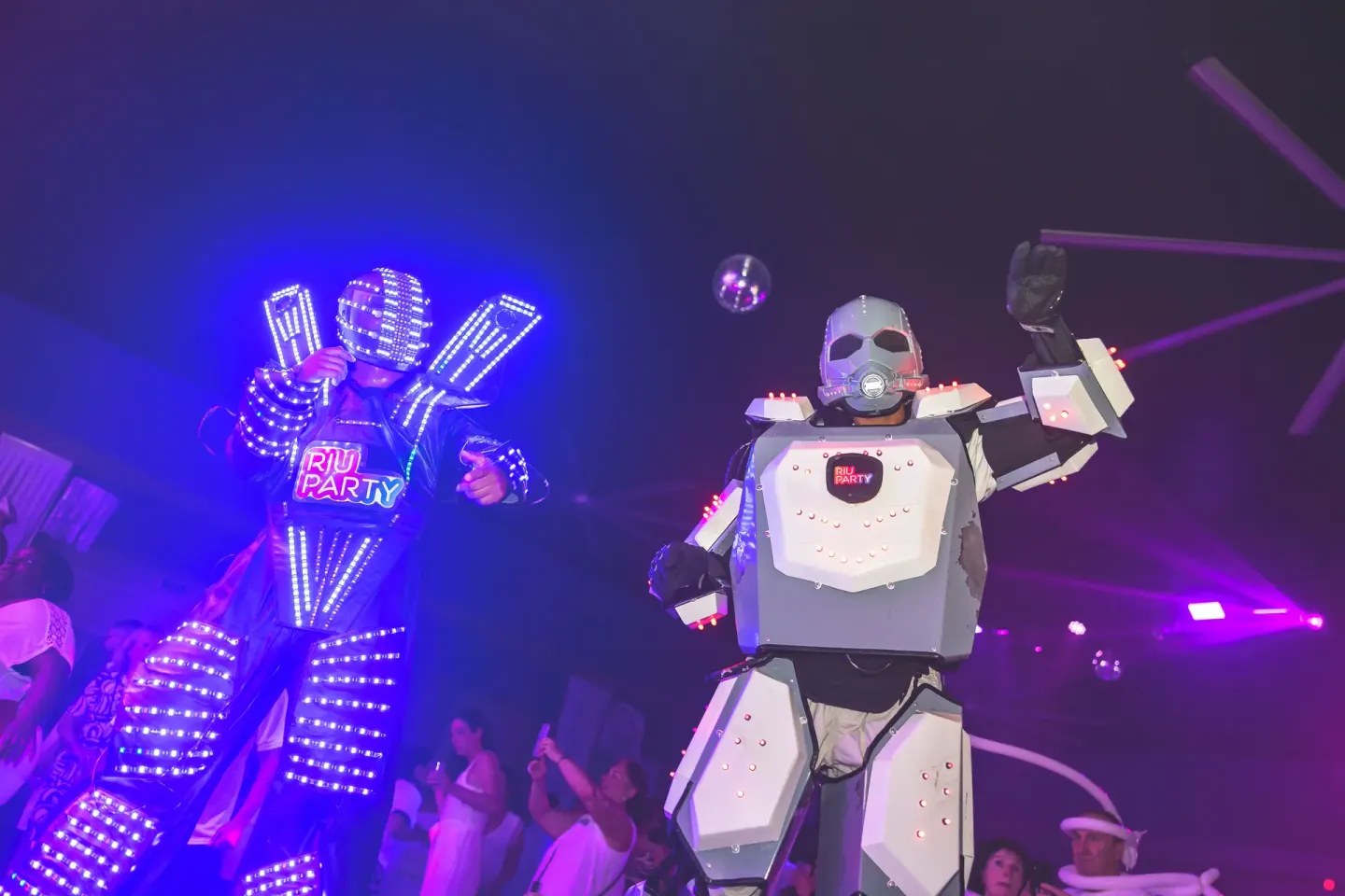Illuminated robot-style performers entertain a crowd at Hotel Riu Palace Aruba.