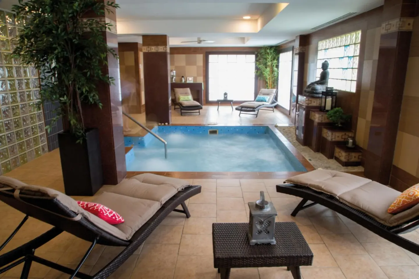 An indoor spa pool with loungers and tile walls is shown at Hotel Riu Palace Aruba.