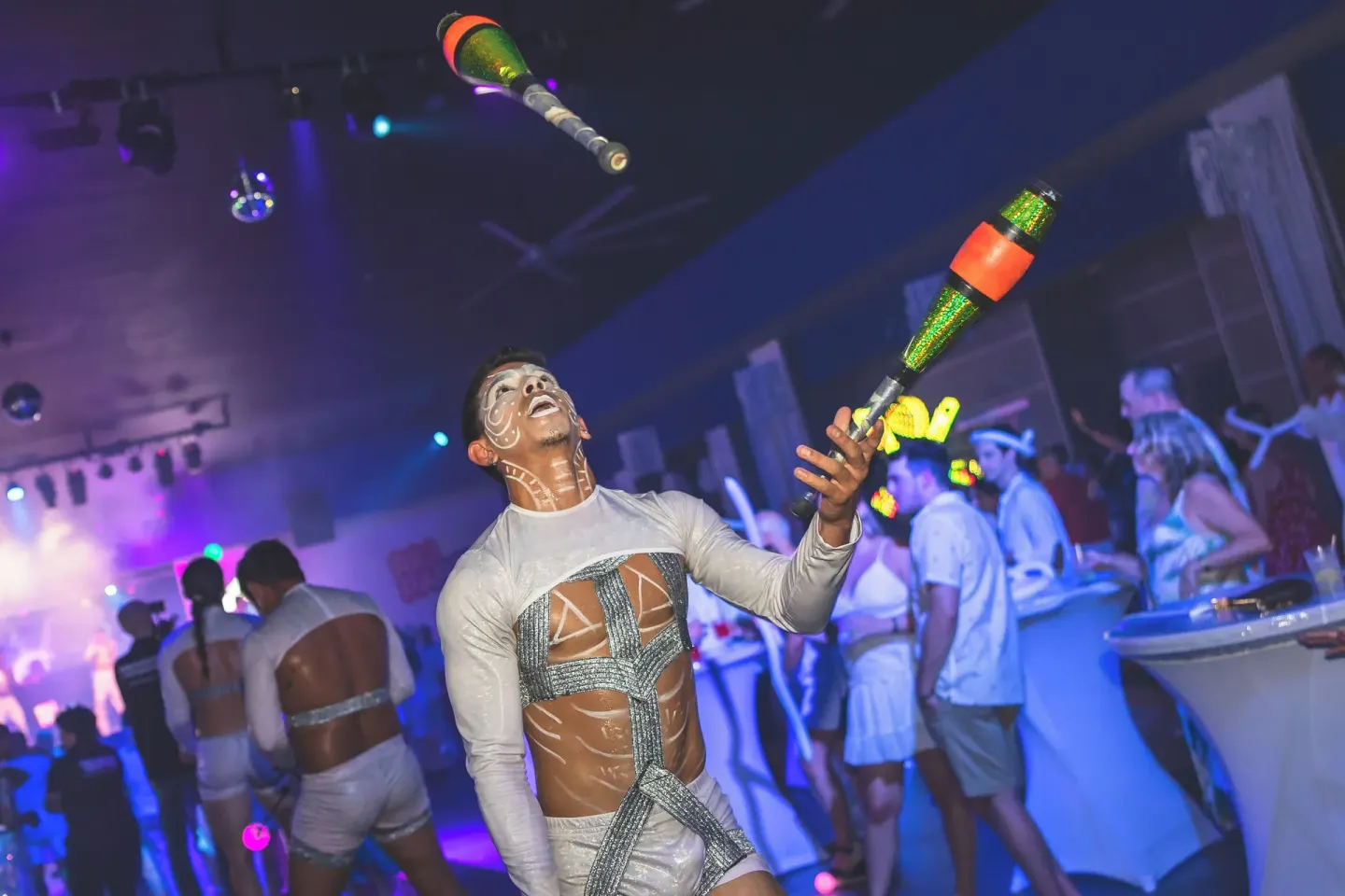 A performer juggles illuminated clubs during a party at Hotel Riu Palace Aruba.