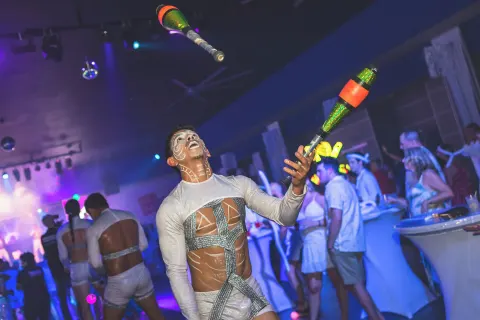 A performer juggles illuminated clubs during a party at Hotel Riu Palace Aruba.