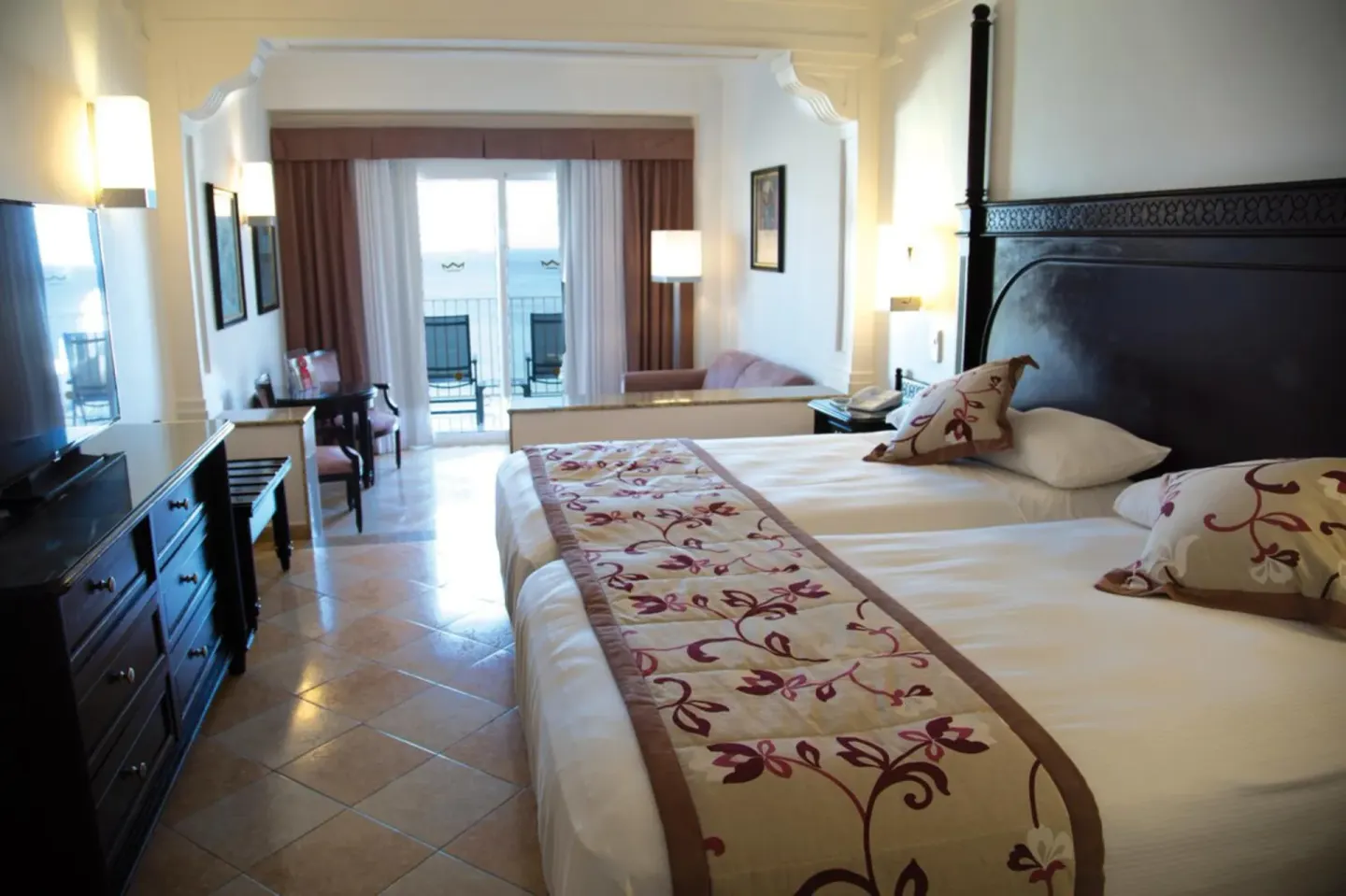 Guest room with two beds and ocean-view balcony at Hotel Riu Palace Aruba
