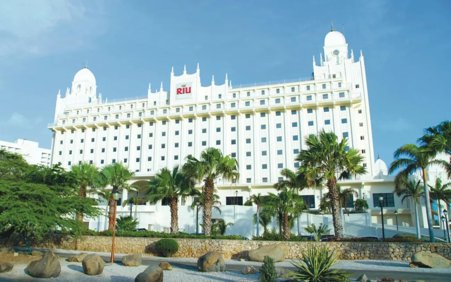 White tower facade and palm landscaping at Hotel Riu Palace Aruba.