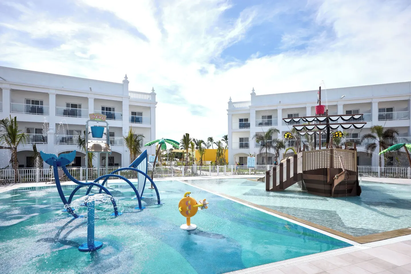 Kids' splash area with water sprays and pirate ship at Hotel Riu Palace Bavaro.