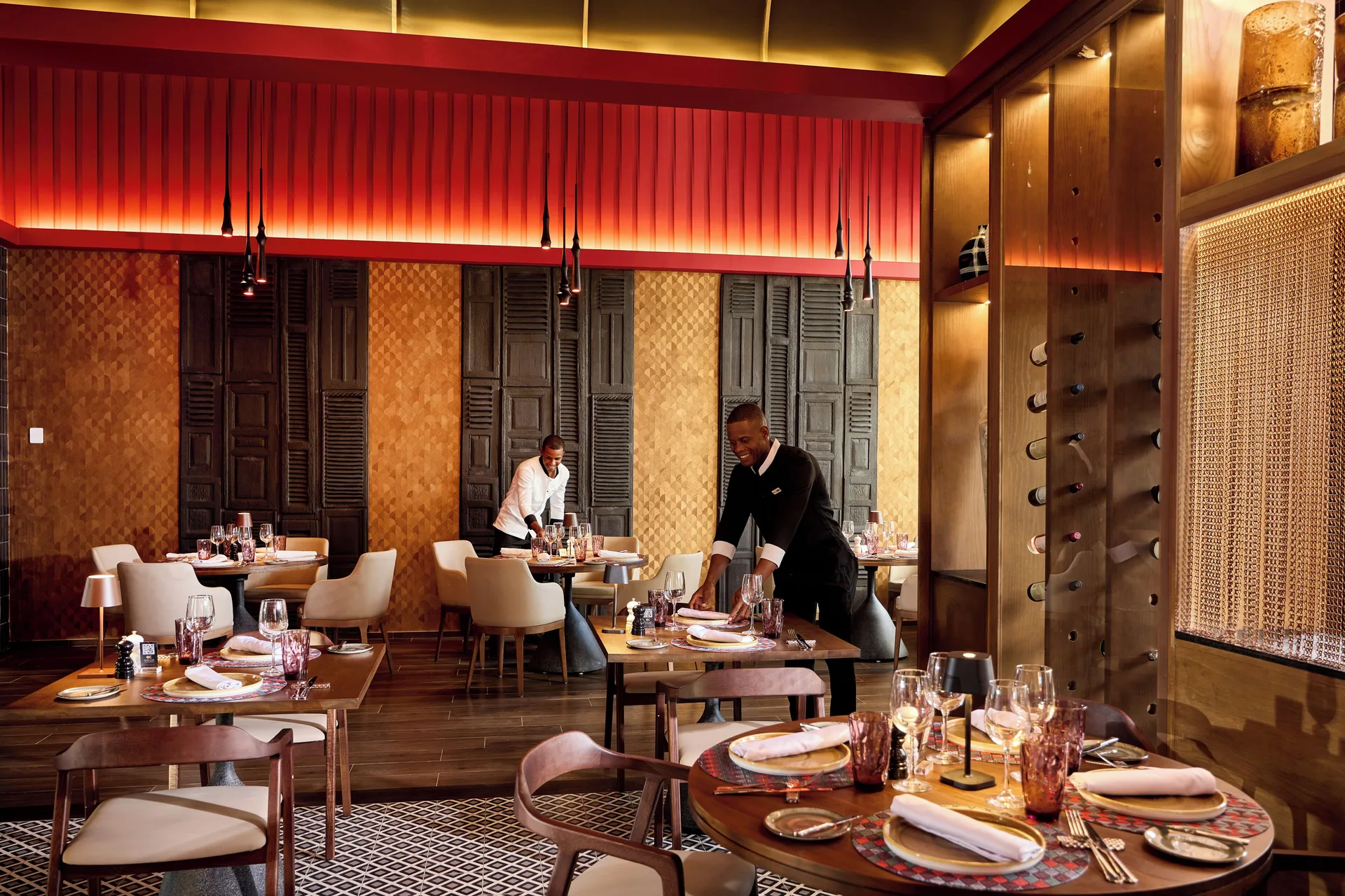 Elegant restaurant dining room with set tables and warm wood details at Hotel Riu Palace Bavaro.